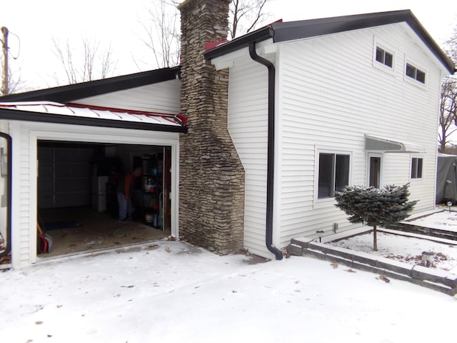 view of snow covered exterior featuring a garage