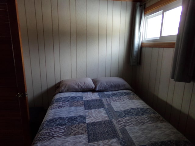 bedroom featuring wood walls