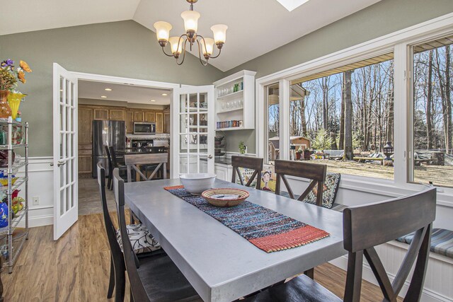 7293 M-116, Ludington, MI 49431 - dining room with french doors, wood finished floors, a chandelier, and vaulted ceiling