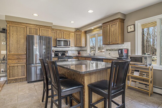 7293 M-116, Ludington, MI 49431 - kitchen with a sink, a kitchen bar, brown cabinets, and appliances with stainless steel finishes