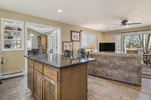 7293 M-116, Ludington, MI 49431 - kitchen featuring ceiling fan with notable chandelier, a healthy amount of sunlight, baseboard heating, and a kitchen island