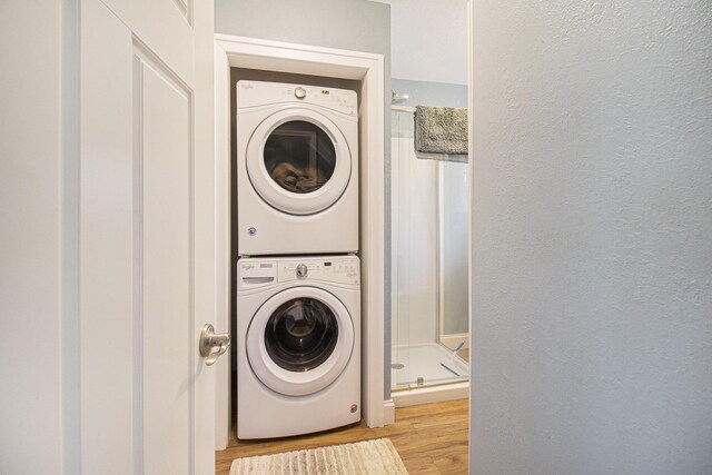 7293 M-116, Ludington, MI 49431 - laundry room featuring laundry area, light wood-style flooring, stacked washer / drying machine, and a textured wall