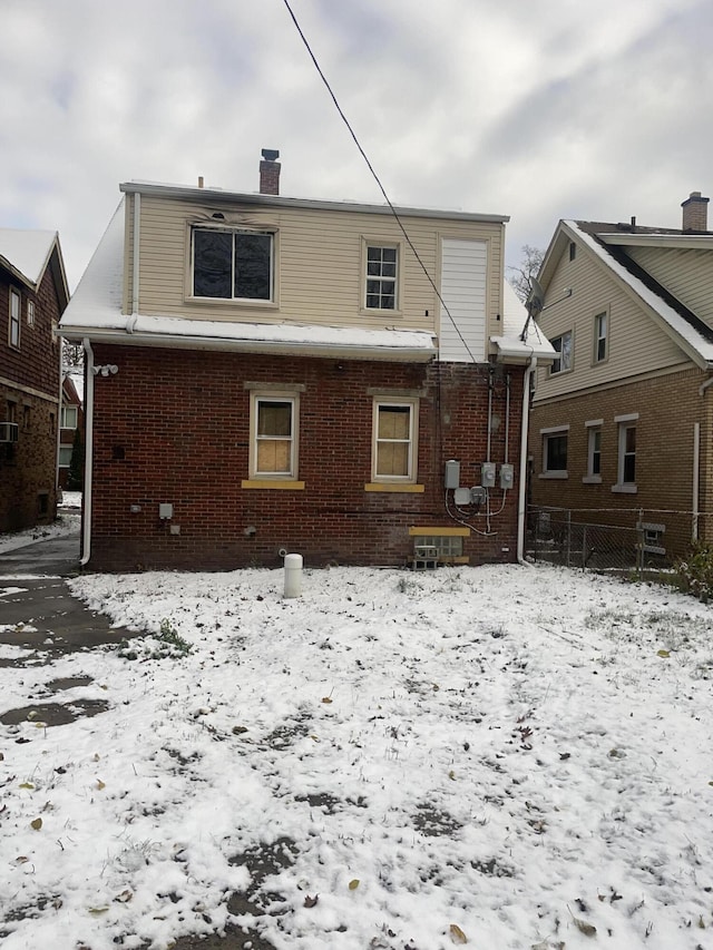 view of snow covered back of property