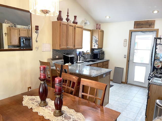 kitchen with decorative backsplash, a wealth of natural light, sink, and vaulted ceiling