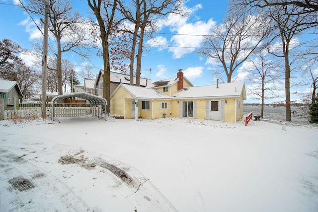 snow covered property with a carport