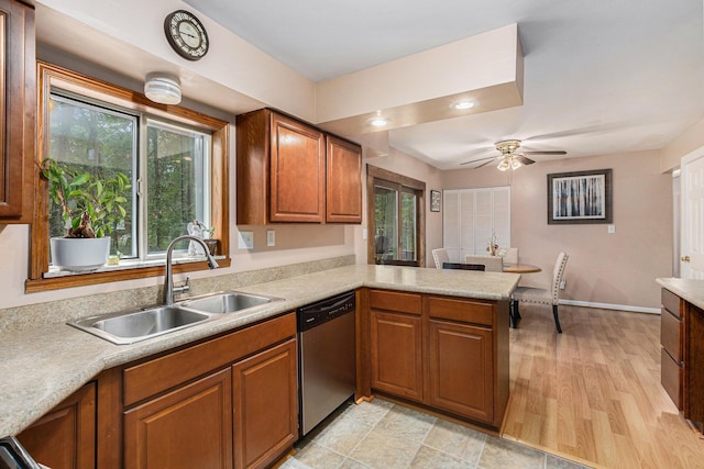 kitchen featuring dishwasher, sink, ceiling fan, light wood-type flooring, and kitchen peninsula