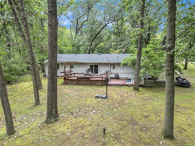 back of property featuring a lawn and a wooden deck