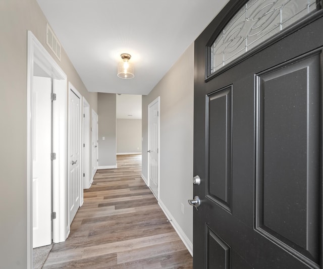 corridor with light hardwood / wood-style floors