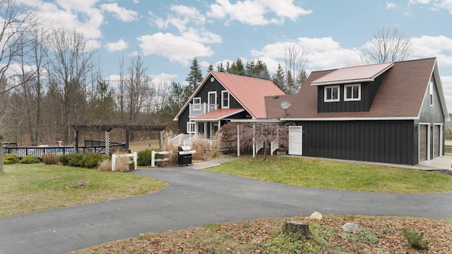 view of front of house with a garage, a pergola, and a front lawn