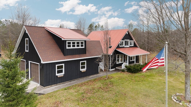 back of house featuring covered porch, a garage, and a lawn