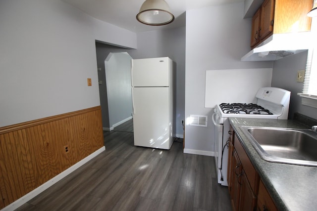 kitchen with dark hardwood / wood-style flooring, white appliances, and sink