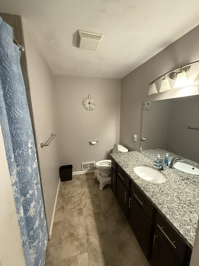 bathroom with tile patterned flooring, vanity, and toilet