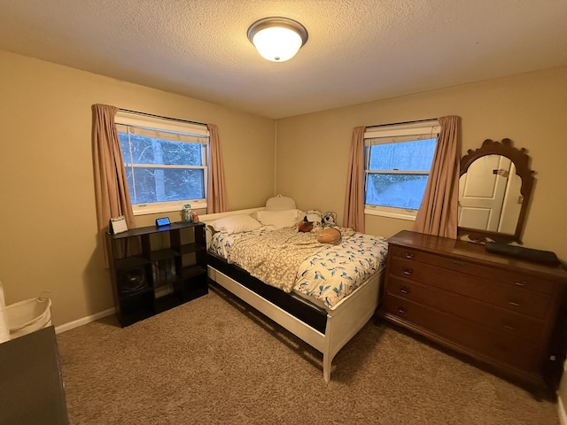 bedroom featuring carpet, a textured ceiling, and multiple windows