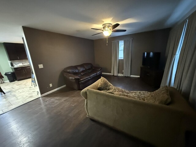 living room with dark hardwood / wood-style flooring and ceiling fan