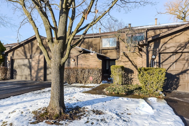 view of snow covered exterior featuring a garage