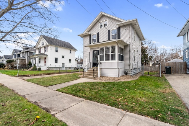 view of front facade featuring a front lawn and a sunroom