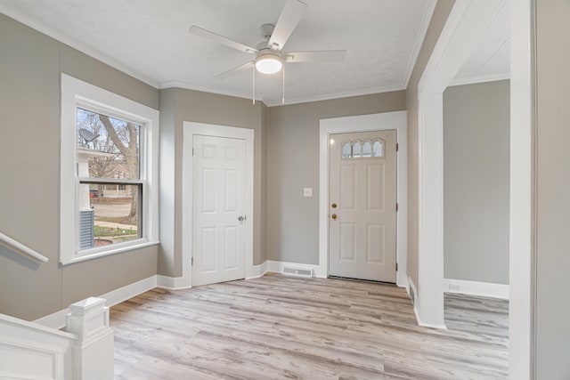 foyer entrance with light wood-type flooring, ceiling fan, and ornamental molding