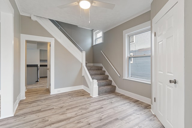 stairs with hardwood / wood-style floors, ceiling fan, and crown molding