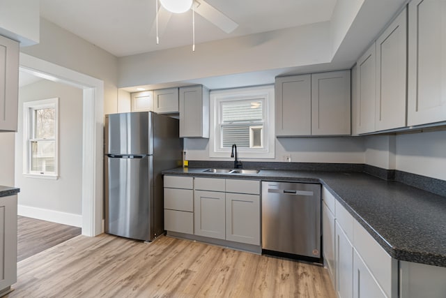 kitchen with gray cabinets, sink, light hardwood / wood-style flooring, and appliances with stainless steel finishes