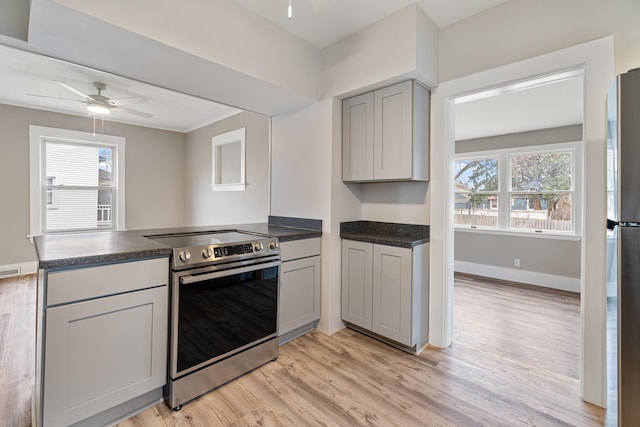 kitchen featuring kitchen peninsula, ceiling fan, electric range, gray cabinets, and light hardwood / wood-style floors