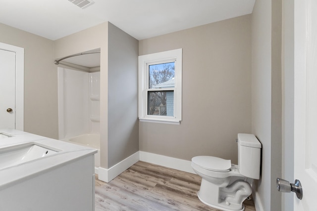 full bathroom featuring hardwood / wood-style floors, vanity,  shower combination, and toilet