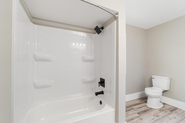 bathroom with shower / bathing tub combination, toilet, and wood-type flooring