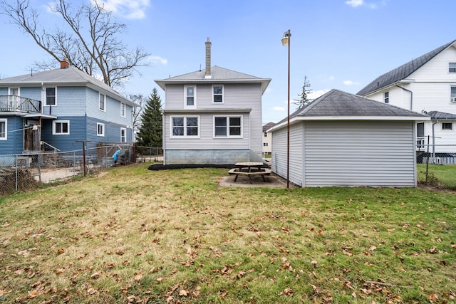 back of property featuring an outbuilding and a yard