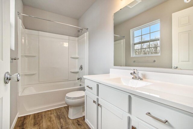 full bathroom with washtub / shower combination, vanity, wood-type flooring, and toilet