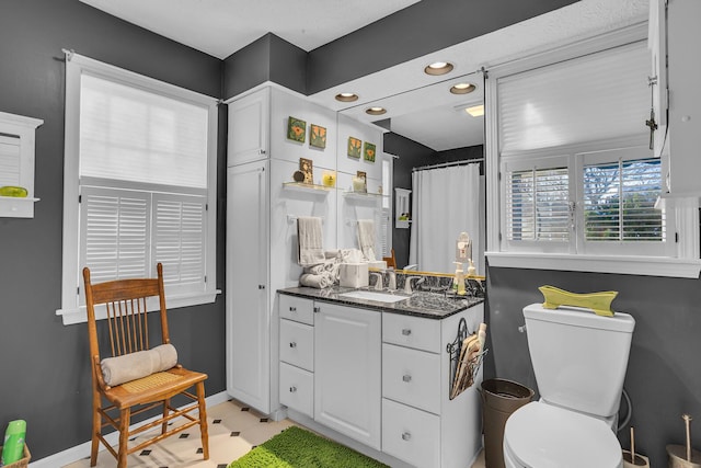 bathroom featuring curtained shower, vanity, and toilet