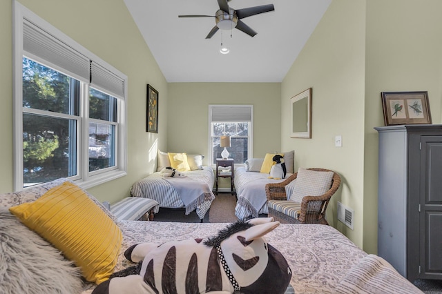 carpeted bedroom with ceiling fan, vaulted ceiling, and multiple windows