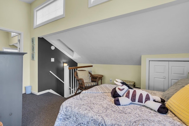 bedroom featuring carpet floors, lofted ceiling with skylight, and a closet