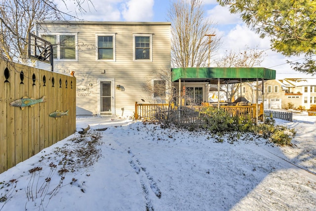 snow covered rear of property featuring a deck