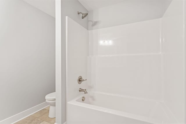 bathroom with tile patterned flooring, tub / shower combination, and toilet