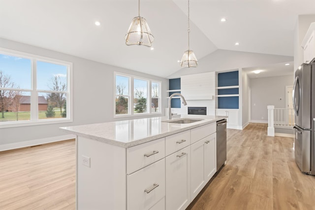 kitchen featuring white cabinetry, a kitchen island with sink, lofted ceiling, and appliances with stainless steel finishes