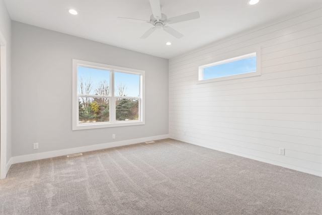 carpeted empty room with ceiling fan and a healthy amount of sunlight