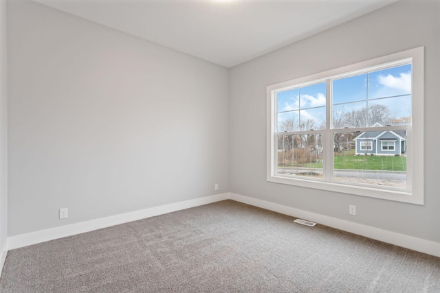 empty room with a wealth of natural light and carpet floors