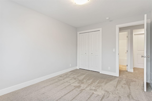 unfurnished bedroom with a closet and light colored carpet