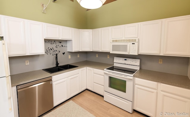 kitchen featuring light wood-type flooring, white appliances, white cabinets, and sink