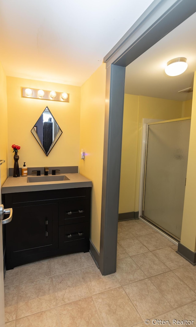 bathroom with tile patterned floors, vanity, and an enclosed shower