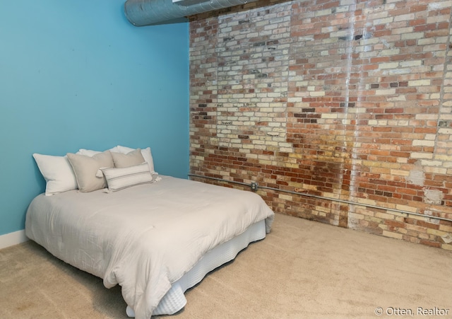 carpeted bedroom featuring brick wall