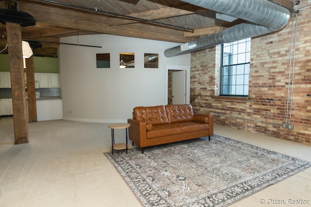 carpeted living room featuring beam ceiling, wood ceiling, a high ceiling, and brick wall