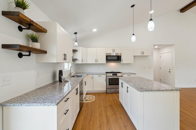 kitchen with white cabinets, pendant lighting, light hardwood / wood-style floors, and stainless steel appliances