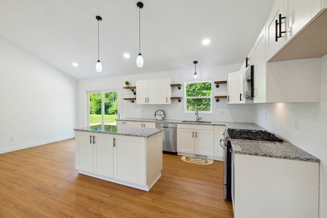 kitchen featuring a kitchen island, appliances with stainless steel finishes, decorative light fixtures, light hardwood / wood-style floors, and white cabinetry