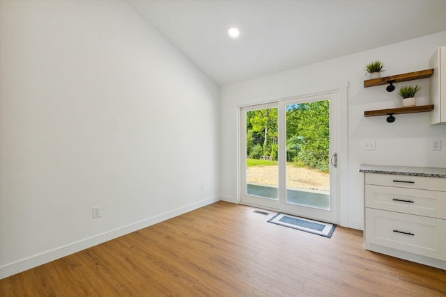 interior space with light hardwood / wood-style floors and lofted ceiling