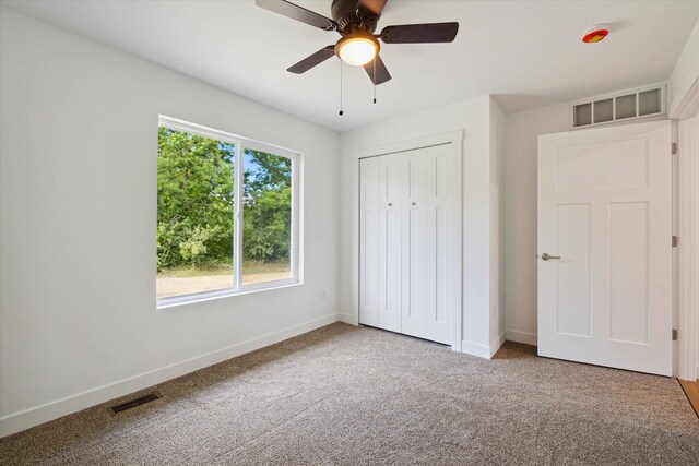 unfurnished bedroom featuring ceiling fan, a closet, and carpet floors