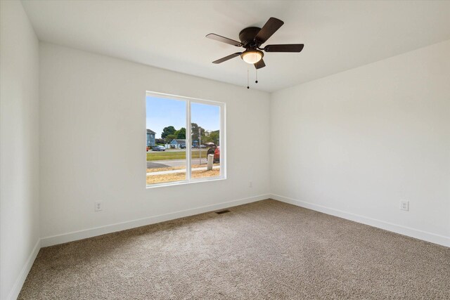 carpeted spare room featuring ceiling fan