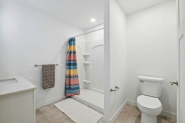 bathroom featuring toilet, vanity, and walk in shower