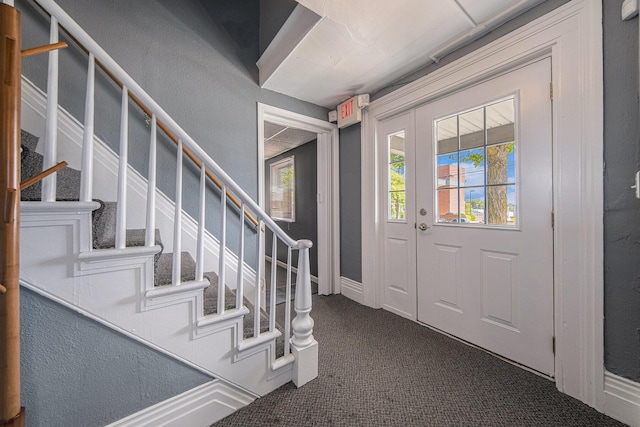 entrance foyer featuring dark colored carpet