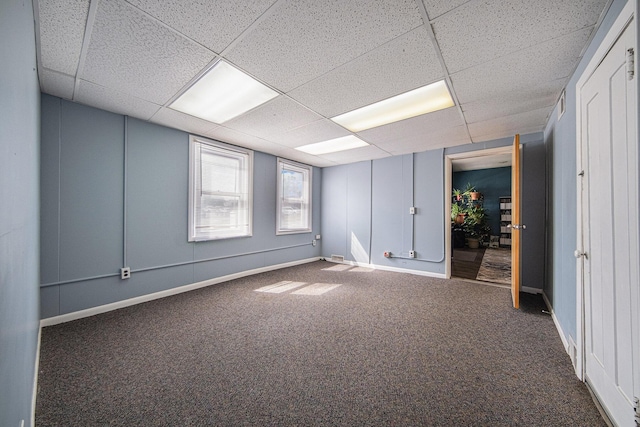 carpeted empty room featuring a drop ceiling