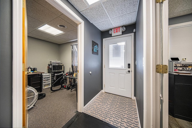 interior space with carpet floors and a drop ceiling